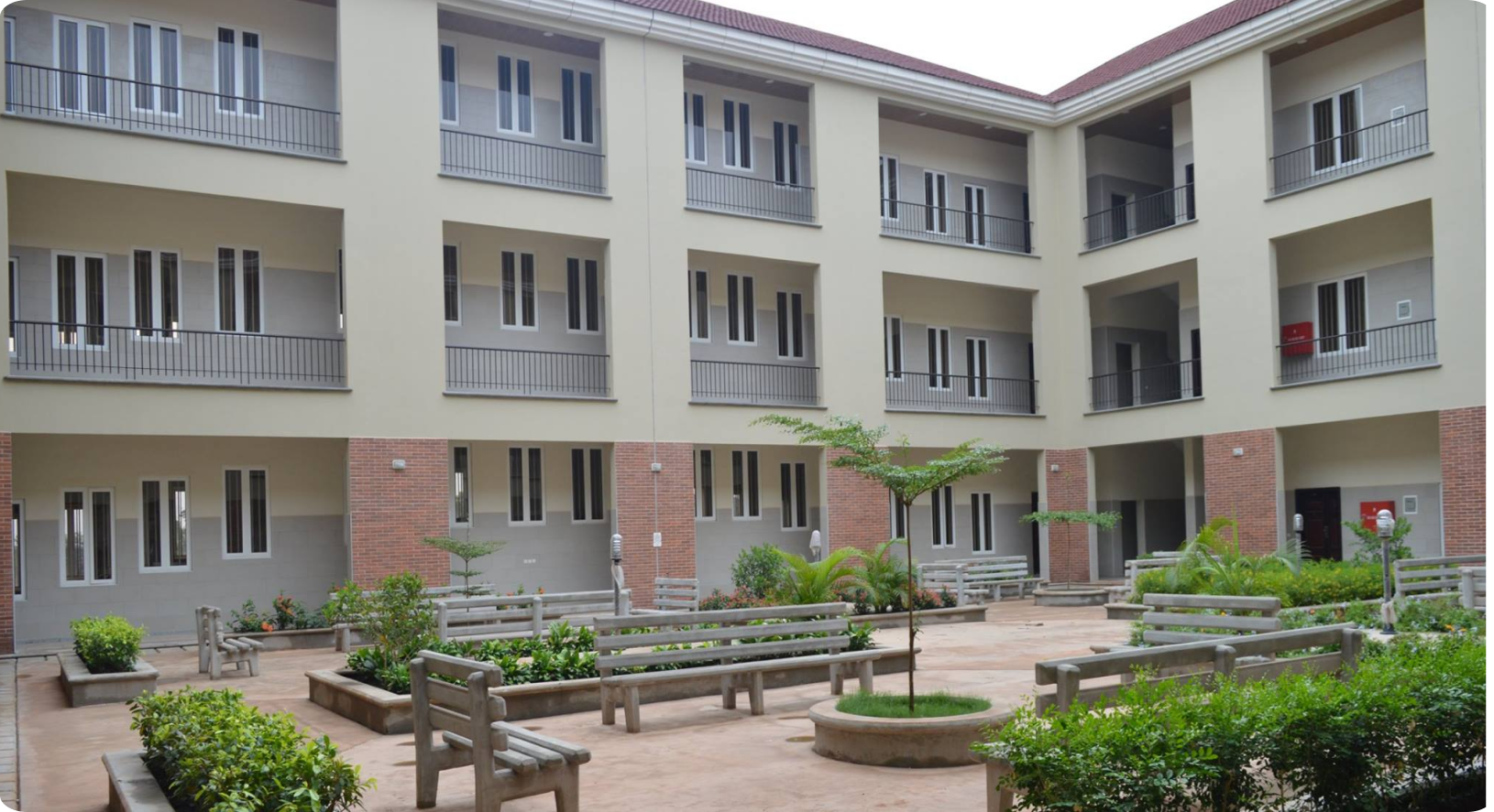 a picture of edo state university uzairue — there are trees and benches